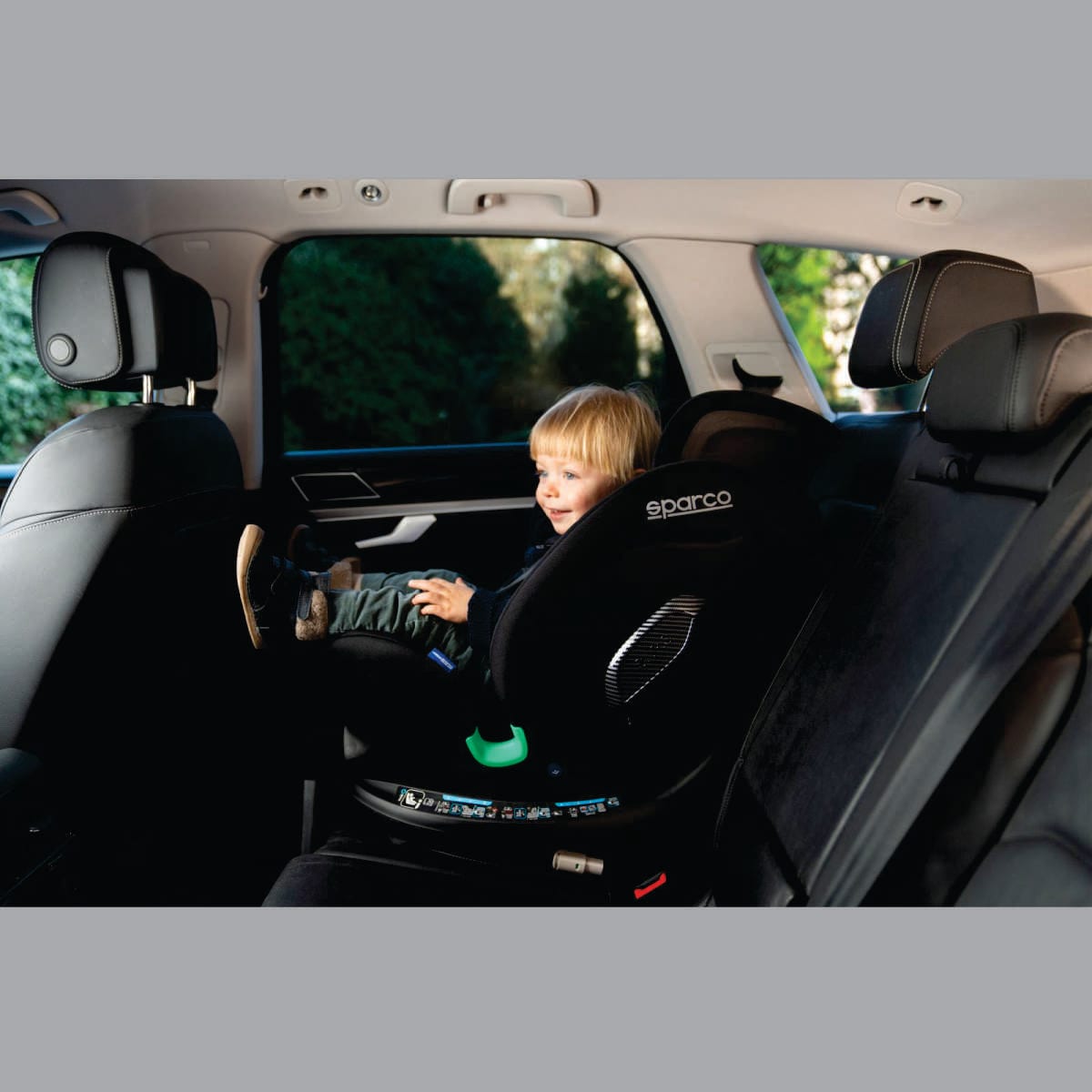 Silla giratoria Sparco SK7000i Rapid negra, instalada en el auto con un niño
